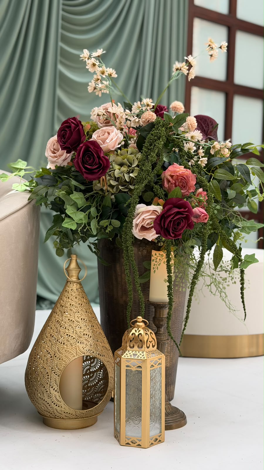 Brass lanterns beside an oversized bouquet of roses and hydrangea